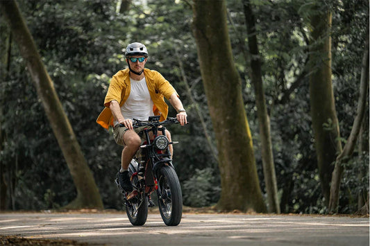 RZOGUWEX X7 rugged off-road e-bike being ridden through a sunlit forest path.