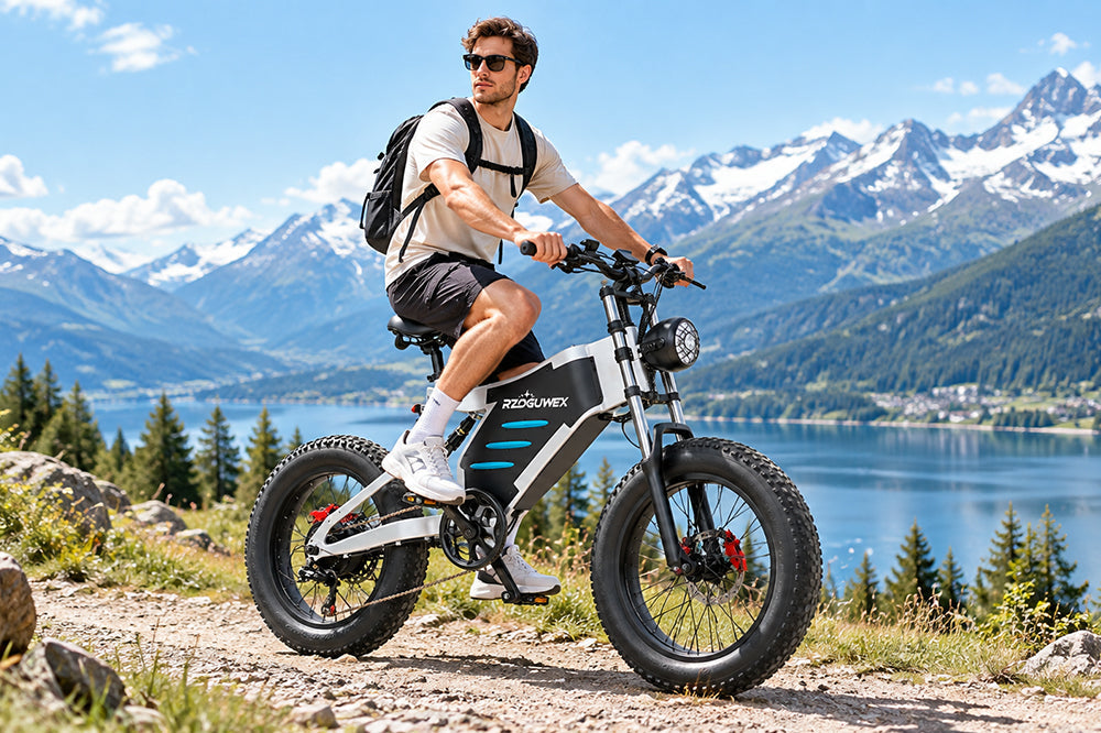 Man with backpack riding RZOGUWEX X5 fat tire electric bike on mountain trail beside lake